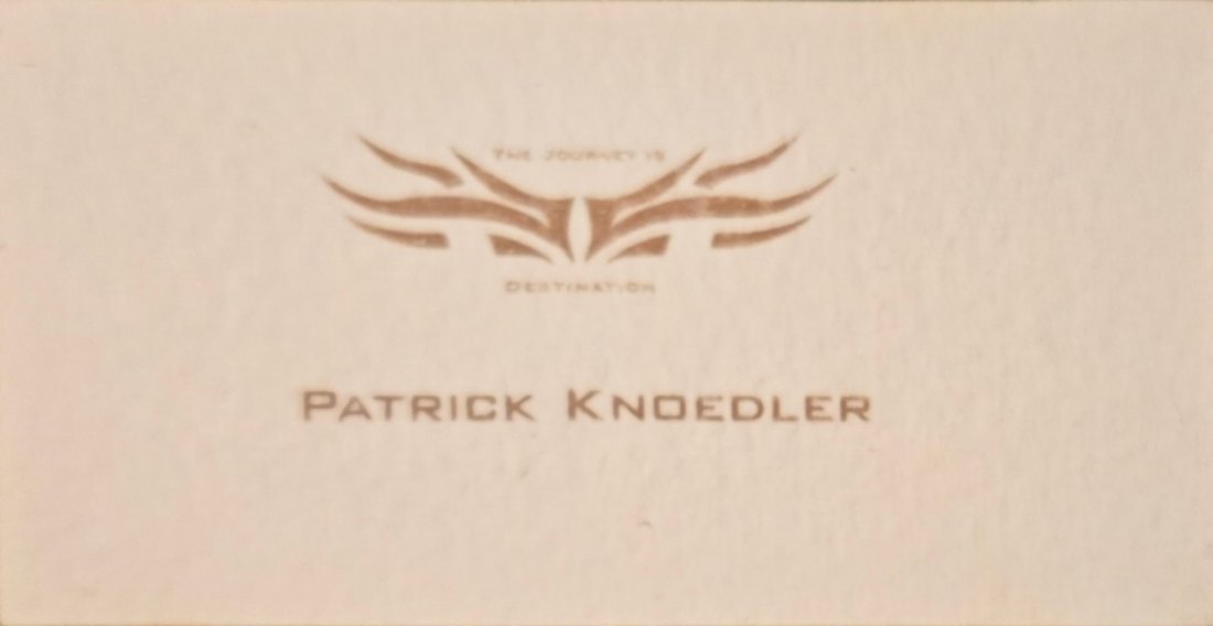 Hand-designed business card with a winged emblem and the motto The Journey Is Destination